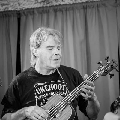 A bass ukulele player lost in the song.