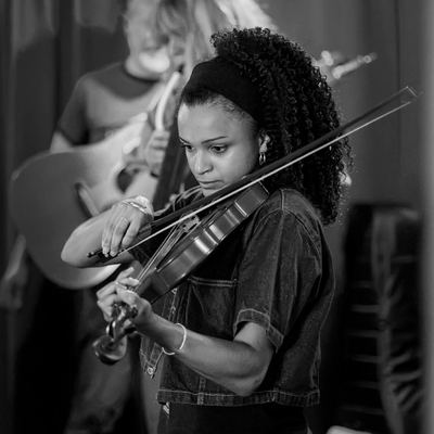 The fiddler mid-tune, bow in motion.