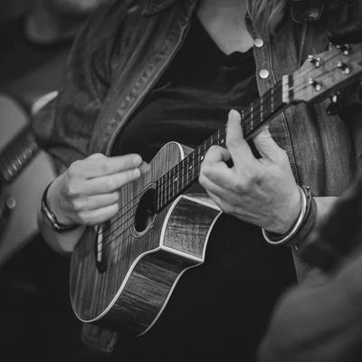 Close-up of hands on a ukulele fretboard.
